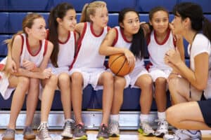 L'entraîneur de l'équipe féminine de basket-ball du lycée donne un discours d'équipe