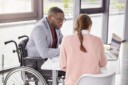 person in a wheelchair in a small meeting with peers