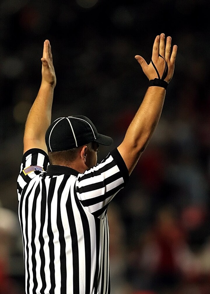 Male referee calling a field goal during a game