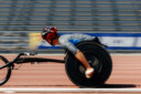 motion blurred men racer on wheelchair racing track stadium