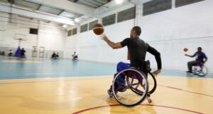 Para athlete passing a ball during a wheelchair basketball game