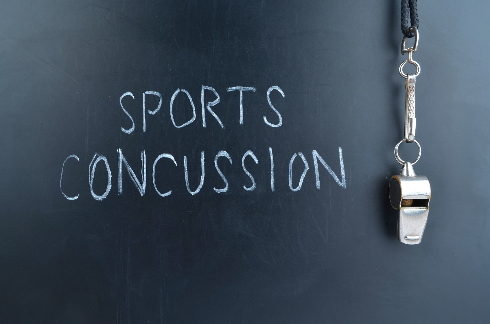 Blackboard with a sport whistle with writing on the board "Sport Concussion"