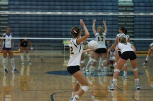 Female volleyball player serving the ball to the other team