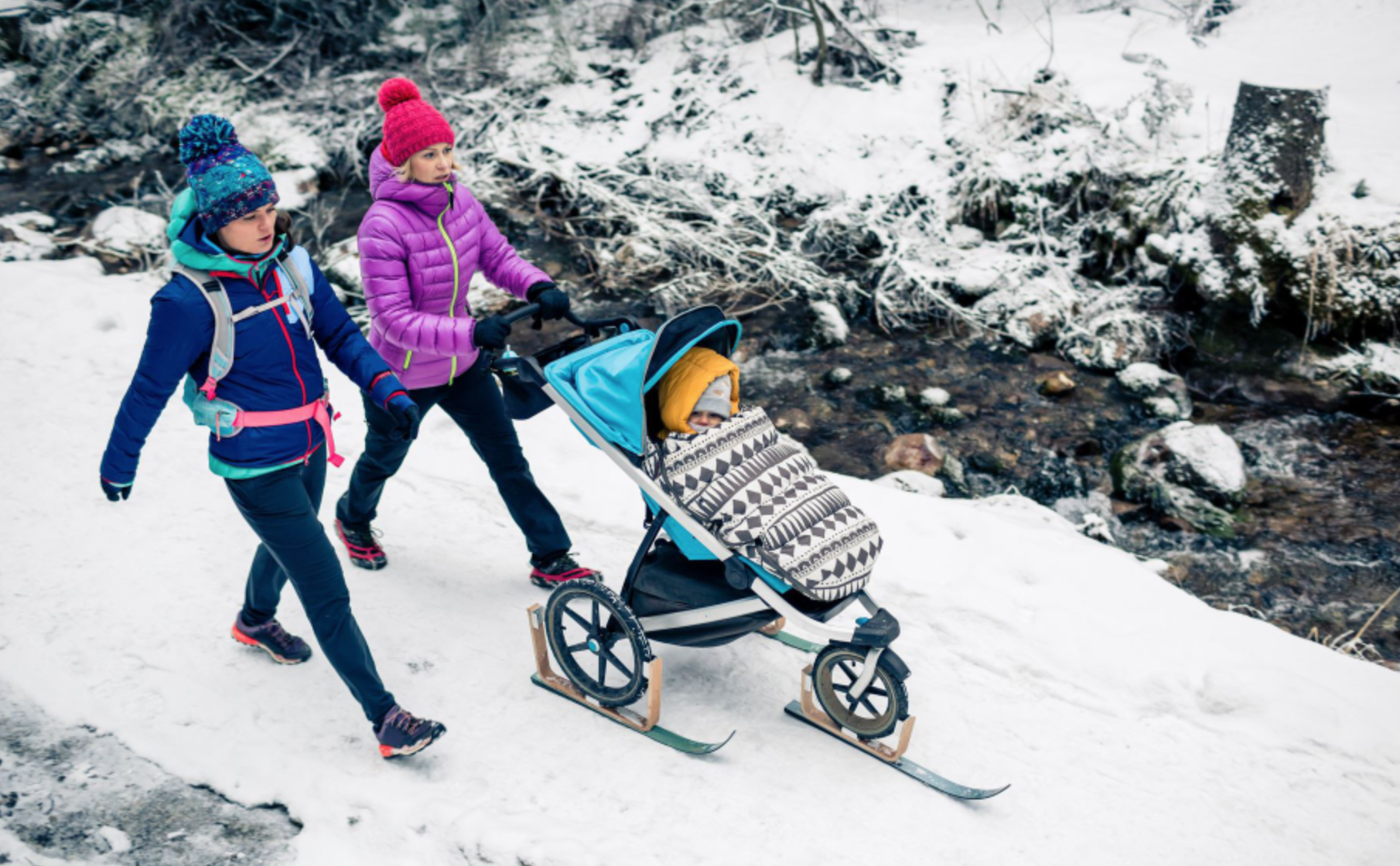 Femmes marchant sur un chemin recouvert de neige avec une poussette