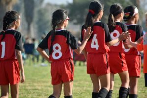 Un groupe de filles se congratulant après un match de football. 