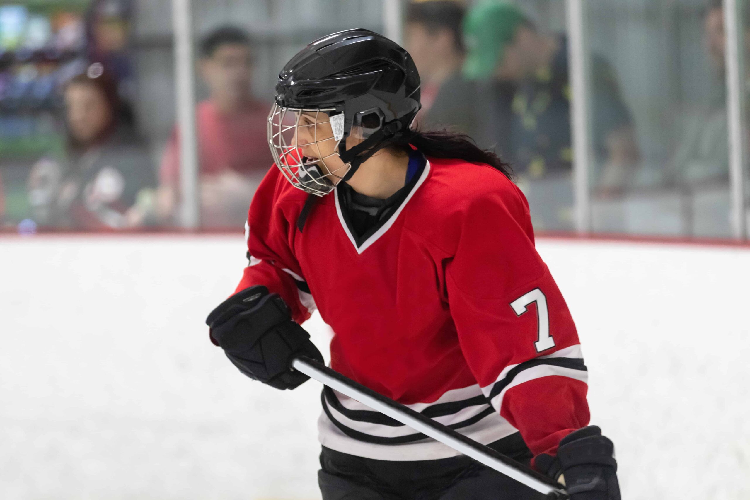 Women's hockey player watching the play on the ice