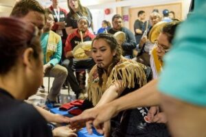Group of indigenous people putting their hands in during a discussion.