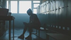 A female athlete in a locker room dealing with mental health