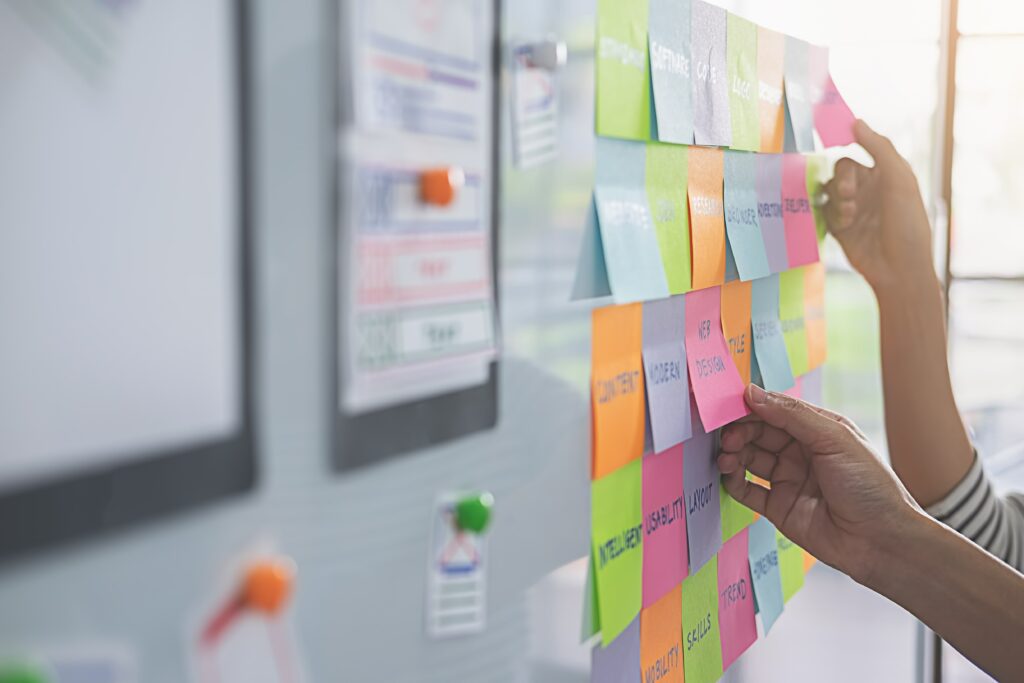 Sticky notes and cue cards with writing on a whiteboard