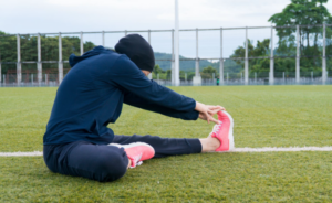 Woman stretching on a soccer field