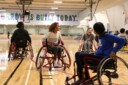 Jeunes pratiquant un sport adapté en fauteuil roulant dans un gymnase