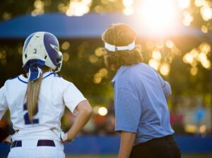 coaching female baseball player