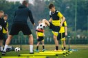Young man training soccer with his coach