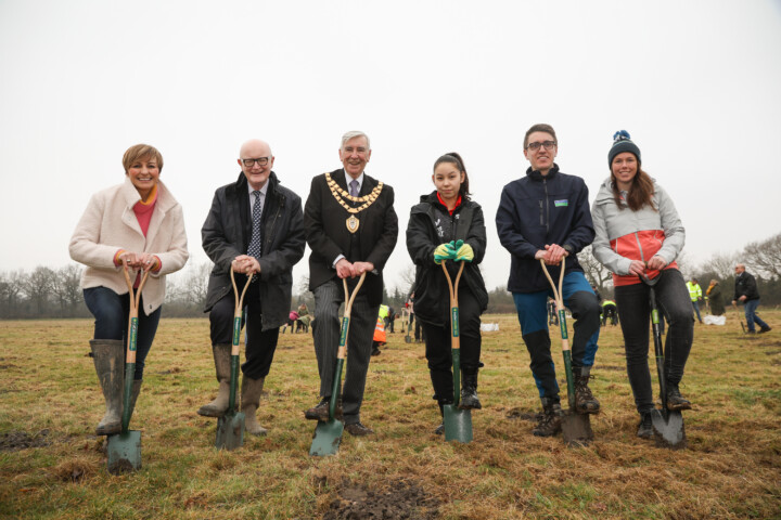 6 organizers of the Birmingham 2022 Commonwealth Games pose with shovels after planting trees.