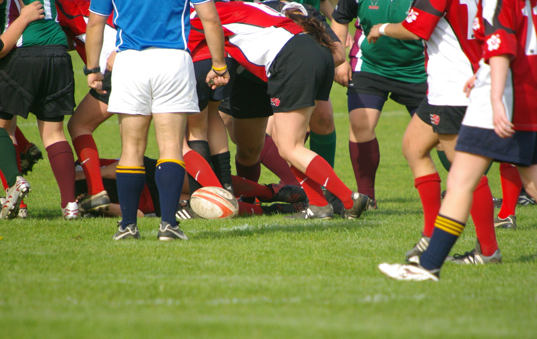 Rugby player on field hurt and players running over