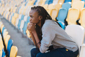 Athlete sitting in the stands alone looking worried