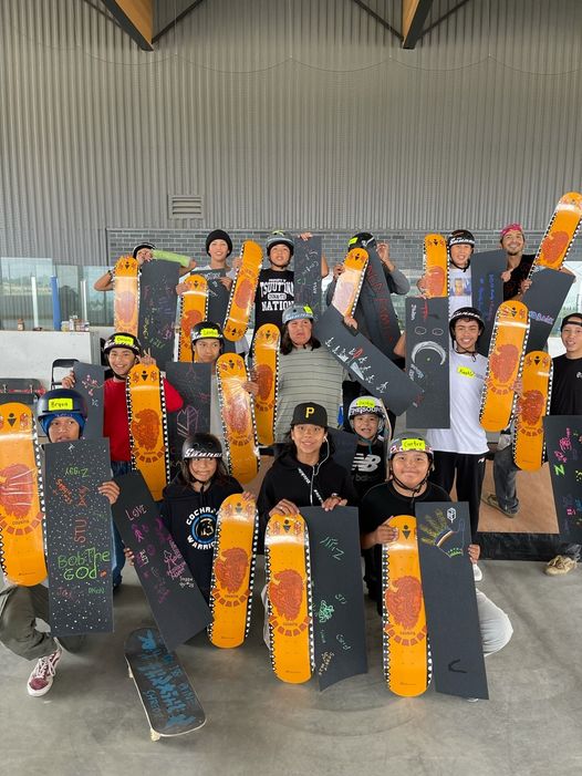 A group of kids with skateboards from the Cousins Skateboard Community non-profit