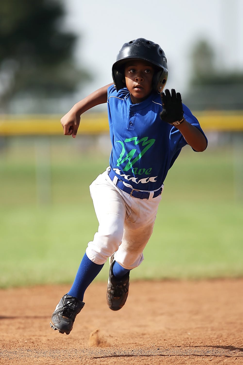 Young baseball player running the bases after a hit