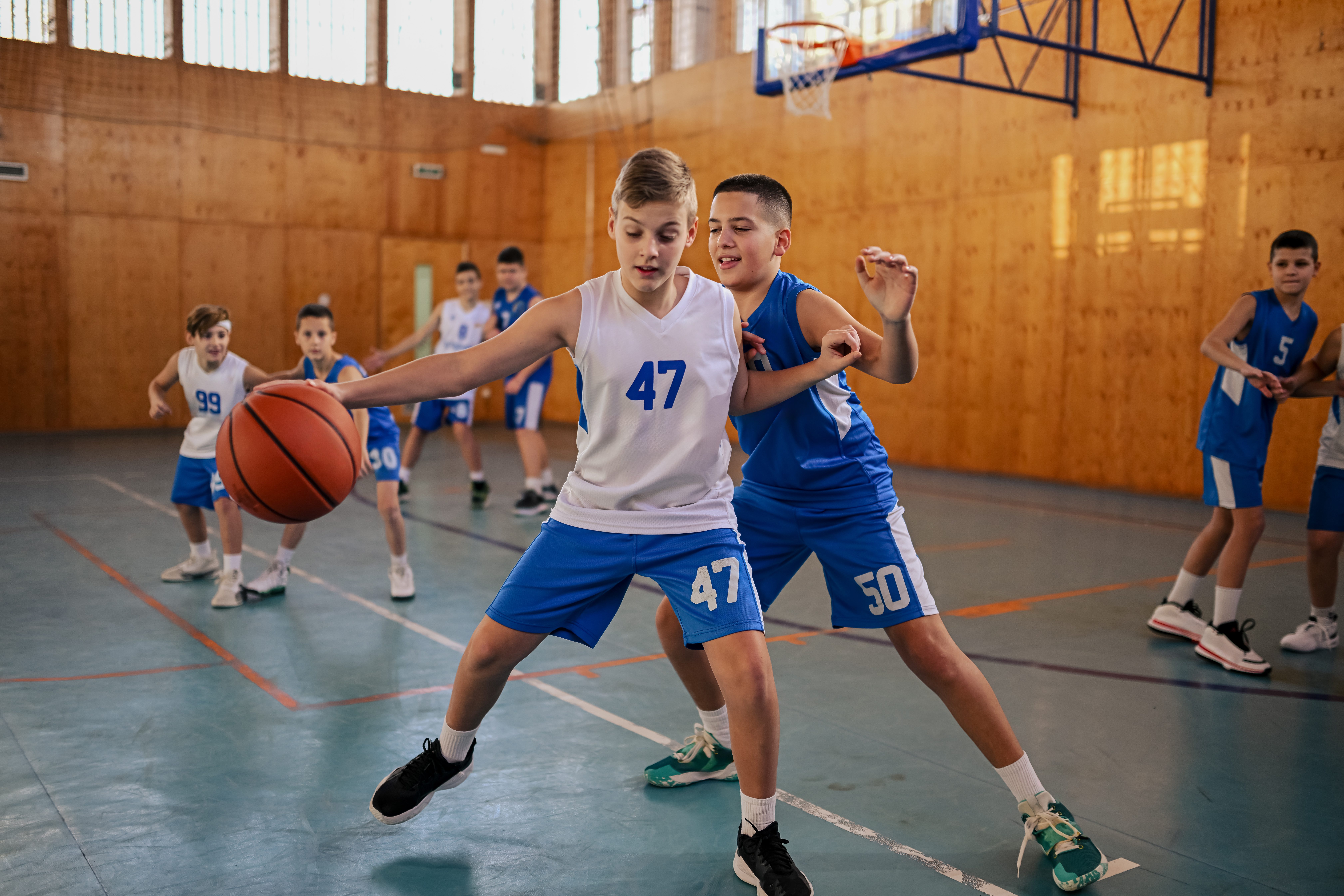 Kids with jersey numbers 47 and 50 in a dynamic basketball sport practice, showcasing agility, teamwork, and competition.